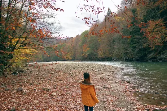 Женщина в желтой куртке у реки, горы, природа, прогулка