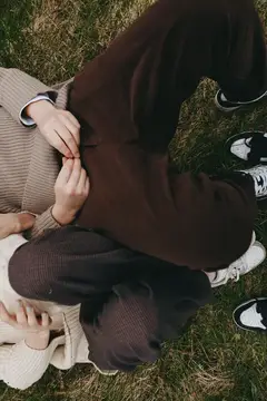Непринужденный и уютный момент на свежем воздухе с друзьями в солнечный день, расслабленная поза, трикотажная одежда, кроссовки и естественное окружение