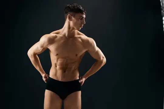 Спортивный мужчина с мускулистым телом позирует крупным планом