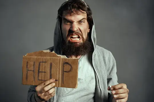 Бездомный бородатый мужчина, бродяга с сигаретой и табличкой «Help»