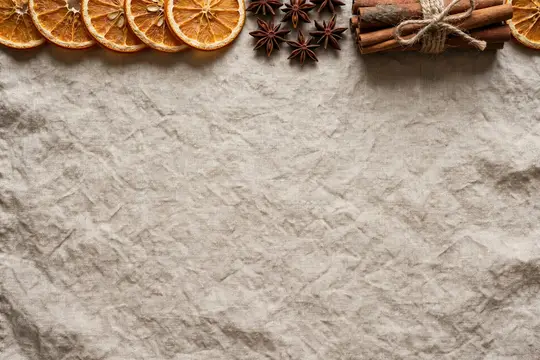 Сушёные апельсины, бадьян и корица на мятой бумаге