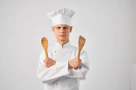 Мужчина в униформе шеф-повара на кухне, профессиональный сервис