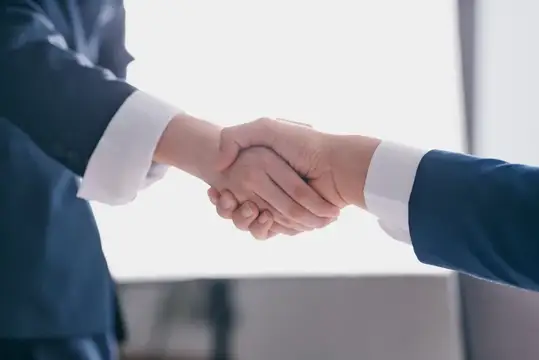 Деловое рукопожатие мужчин в синих костюмах в офисе