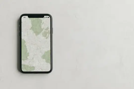 Смартфон с картой на экране лежит на светлом столе