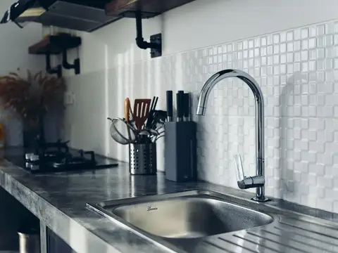 Современная кухня с металлической мойкой и чёрным смесителем