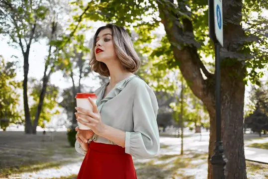 Женщина в парке с чашкой напитка, прогулка, отдых, деревья