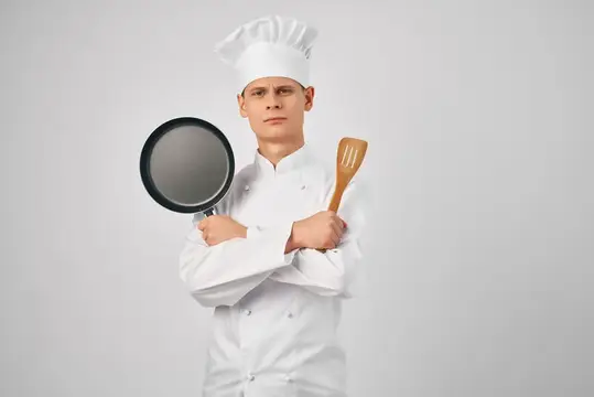 Мужчина в одежде повара работает на кухне — это сотрудник