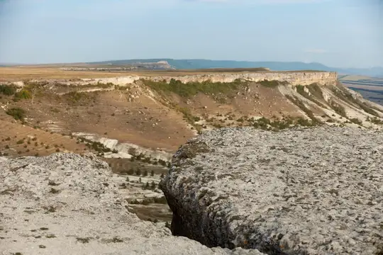 Скалистый обрыв с видом на долину и холмы