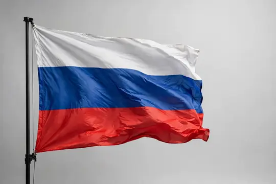 Российский флаг развевается на флагштоке на сером фоне