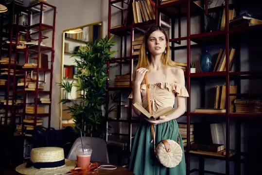 Весёлая женщина читает книгу в кафе, отдыхая