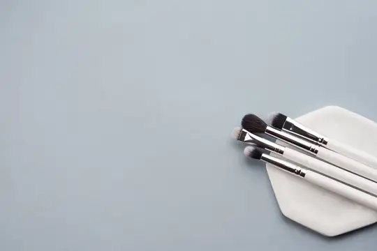 Профессиональные кисти для макияжа на подставке на сером фоне, свободное пространство, обрезанный вид