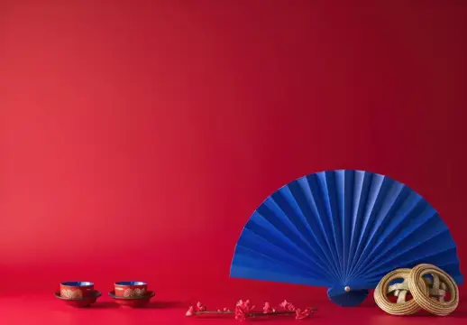 Синяя веерная композиция с чашками и веточкой на красном фоне