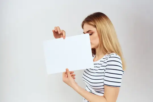 Женщина держит в руках лист бумаги