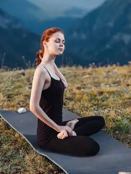 Спортивная женщина занимается гимнастикой на природе в горах