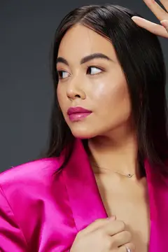Симпатичная женщина с ярким макияжем, в розовом мини-платье современного стиля на изолированном фоне