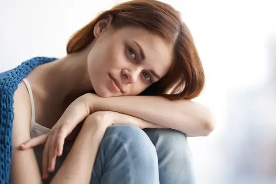 Симпатичная привлекательная женщина в синюю клетчатую рубашку улыбается дома
