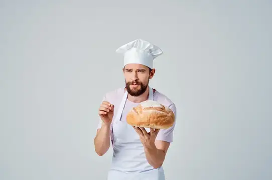 Мужчина в поварской форме готовит еду, занимается выпечкой