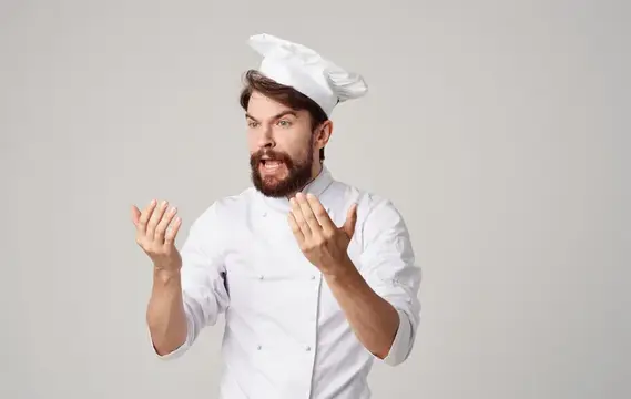 Бородатый повар в белом колпаке жестикулирует и кричит