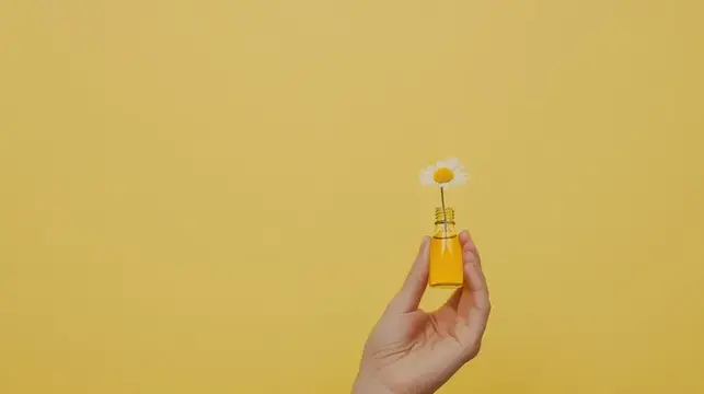 Рука держит маленький флакон с ромашкой на жёлтом фоне