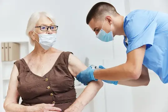 Пожилая женщина в больнице проходит иммунизацию, что обеспечивает безопасность пациента и лечение