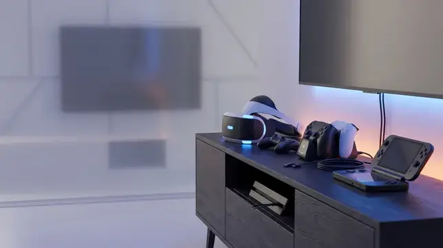 Игровая консоль и VR-шлем на тумбе под телевизором