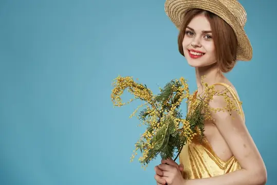 На фотографии высокого качества изображена симпатичная женщина с букетом цветов, что отражает разнообразный образ жизни, празднование Международного женского дня и веселье