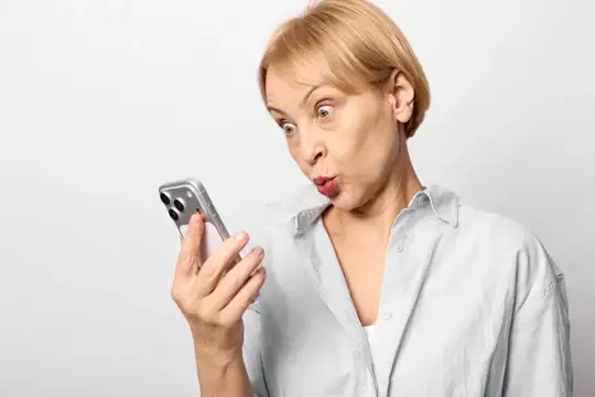 Женщина держит смартфон с удивленной эмоцией по поводу технологий и коммуникации