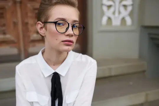 Студент на улице возле здания отдыхает после учёбы