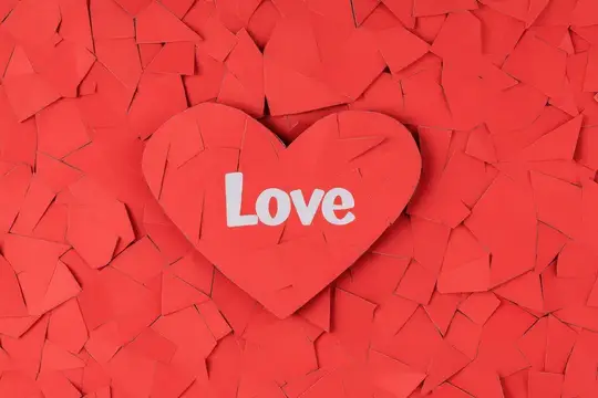 3D-рендер красного сердца с надписью Love на фоне осколков