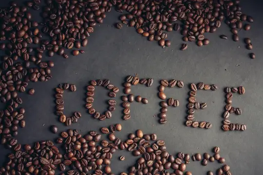 Кофейные зёрна, выложенные словом coffee на тёмном фоне