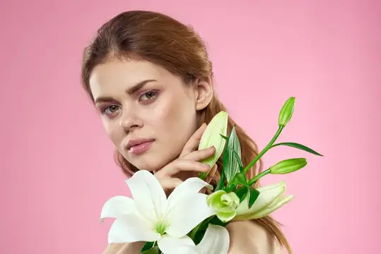 Молодая женщина с белыми лилиями на розовом фоне