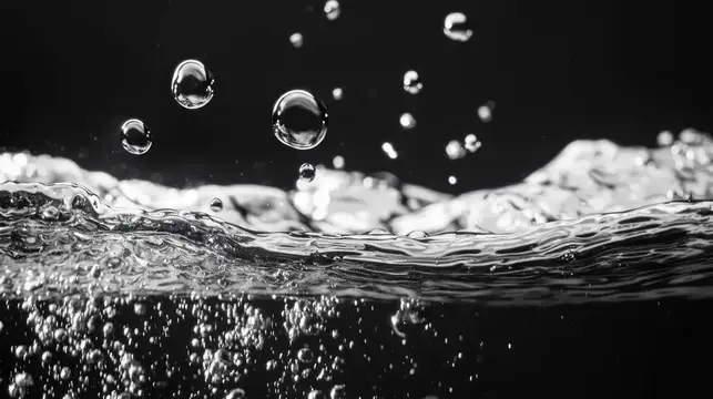 Капли воды взлетают над бурлящей поверхностью на чёрном фоне
