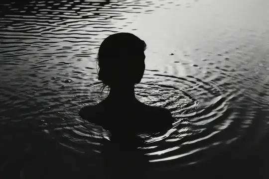 Силуэт женщины в воде среди расходящихся кругов