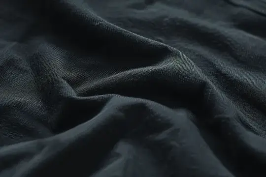 Тёмная ткань с мягкими складками крупным планом