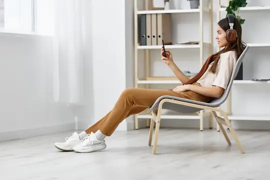 Девушка расслабляется, слушая музыку в наушниках через смартфон