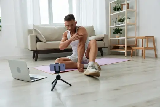 Спортивный мужчина делает растяжку перед камерой на полу гостиной