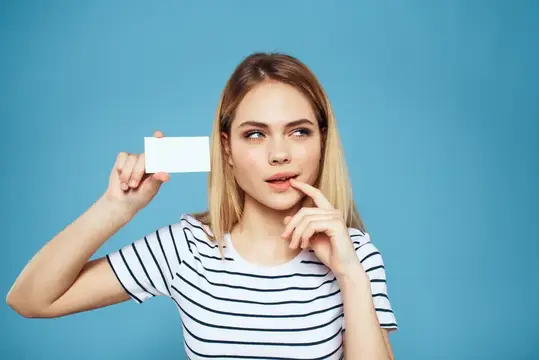 Женщина с визитной карточкой в руках, на ней полосатая футболка, синий фон, свободное пространство для текста