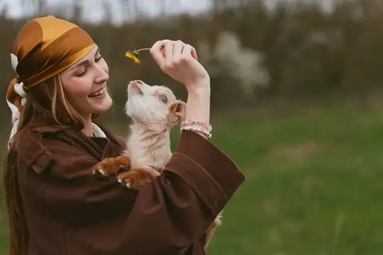 Искренний момент на природе: женщина и козленок разделяют любопытство и радость