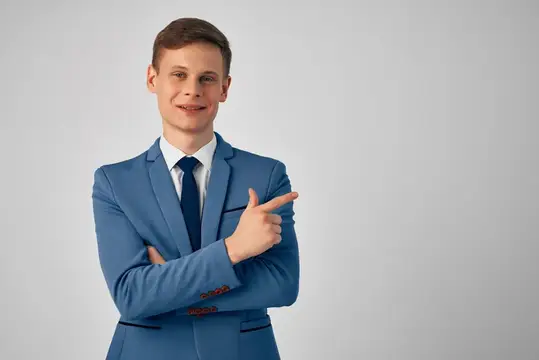 Улыбающийся парень в синем костюме показывает пальцем в сторону