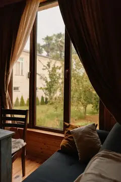 Вид из окна загородного дома на зелёный сад