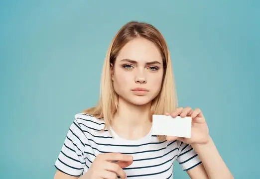 Привлекательная женщина держит в руке визитную карточку