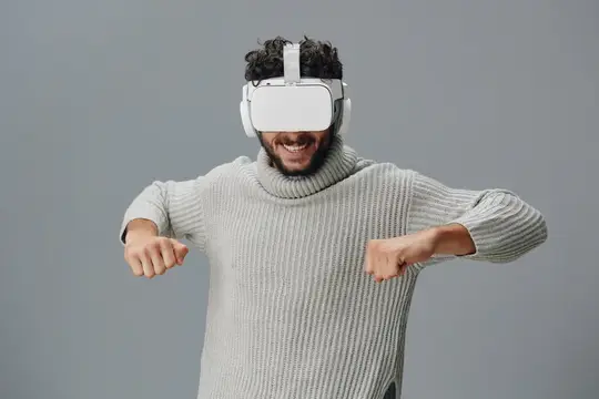 Улыбающийся темнокожий мужчина в VR-очках управляет виртуальной реальностью