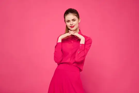 Молодая женщина в красном на розовом фоне