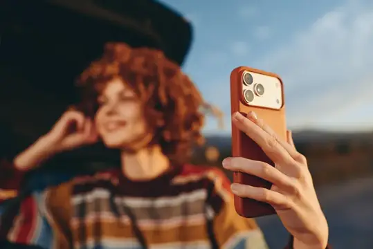 Женщина делает селфи в стиле лайфстайл, поднимая смартфон к камере