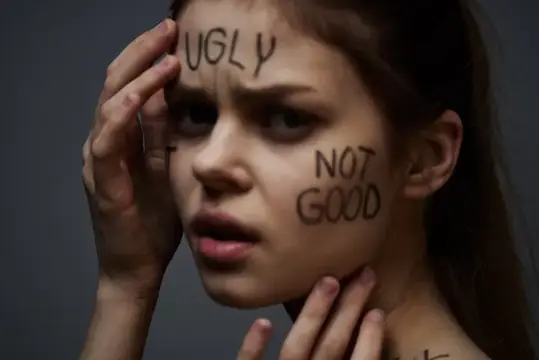 Молодая девушка с надписями Ugly и Not Good на лице