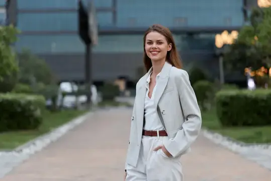 Улыбающаяся девушка в светлом костюме на городской улице