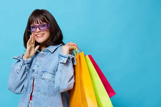 Улыбчивая девушка в фиолетовых очках с разноцветными пакетами
