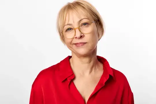 Женщина в очках, портрет, студия, пожилая, красная блуза, улыбается, композиция с лицом по центру, погрудный снимок, мягкая улыбка, мягкий свет, простой белый фон, профессионально