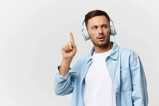 Молодой мужчина в наушниках поднимает палец вверх