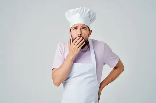 Профессиональный шеф-повар мужского пола работает на профессиональной кухне, занимаясь приготовлением изысканных блюд